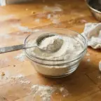 A small bowl of powdered egg replacer with a measuring spoon